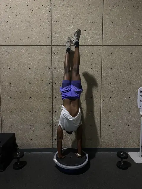 Daniel holding a handstand on a balance ball